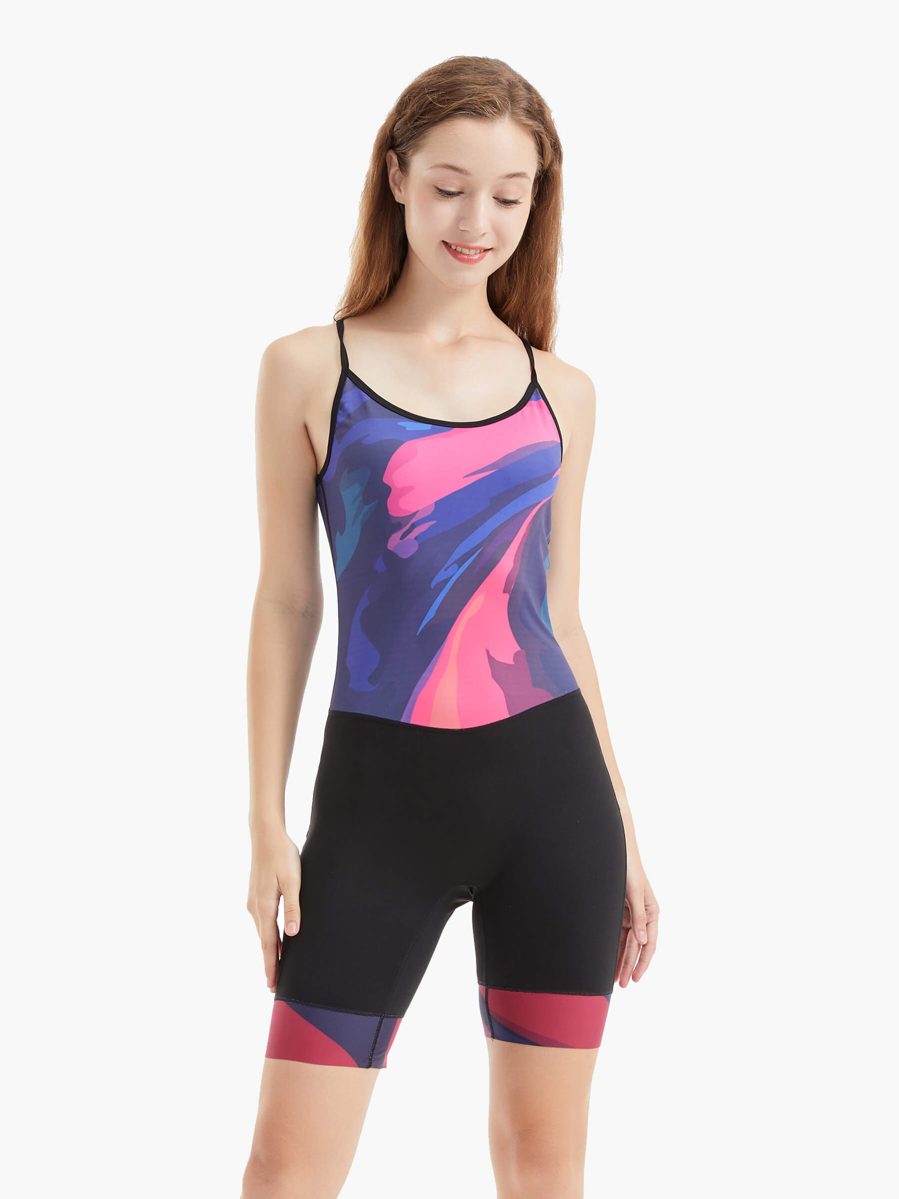 Front view of the Velocity Women’s Rowing Suit, also known as a unisuit, zootie, or AIO, featuring a vibrant abstract design in pink, purple, and blue with a sleek black bottom.